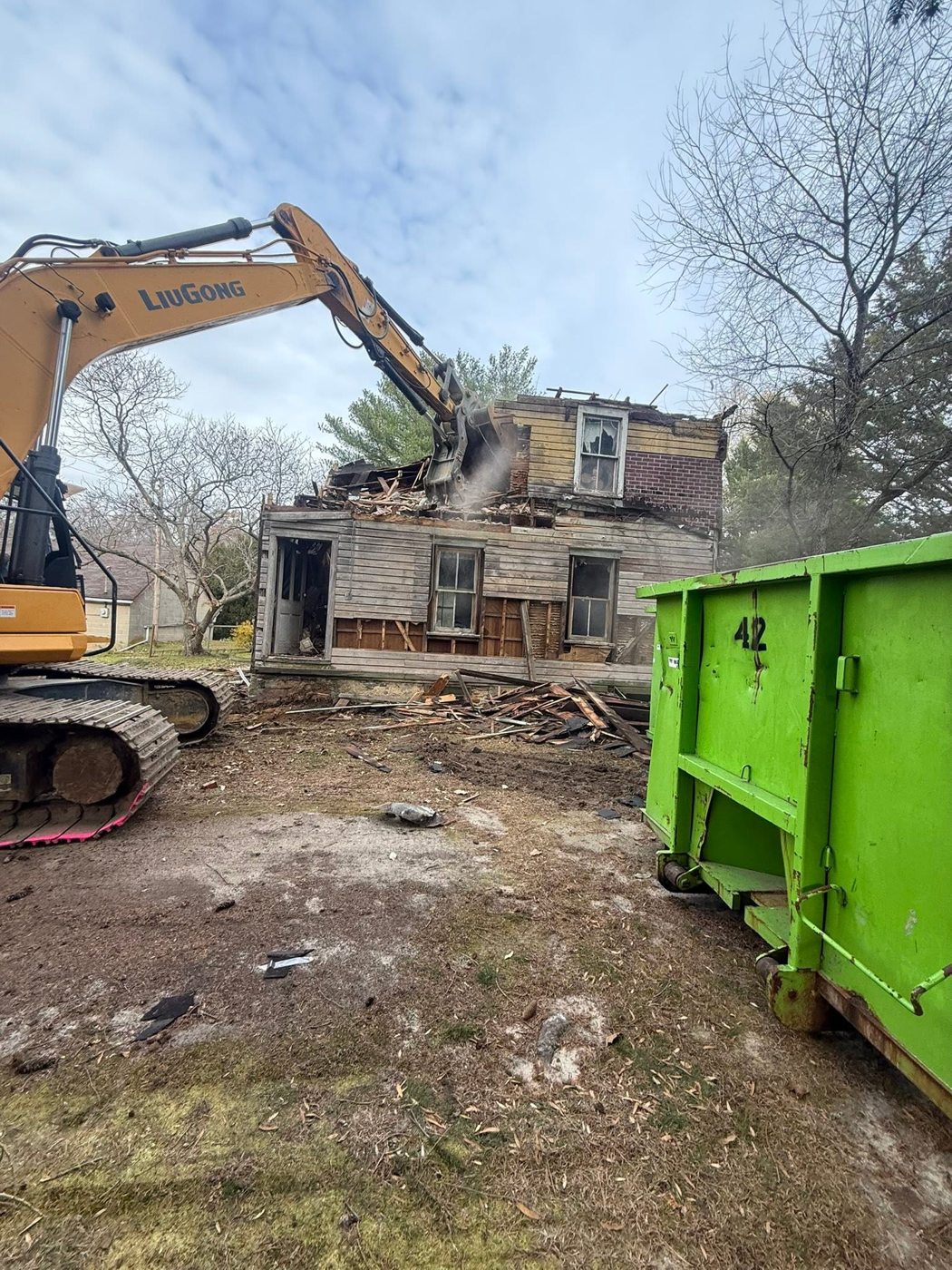 A two story house coming down mid demolition