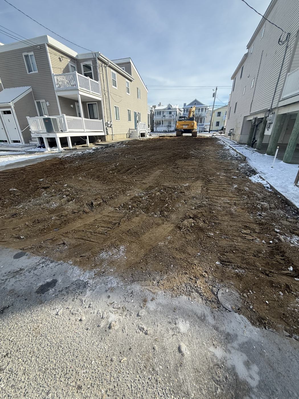 A cleared and graded dirt lot between two shore homes after a teardown